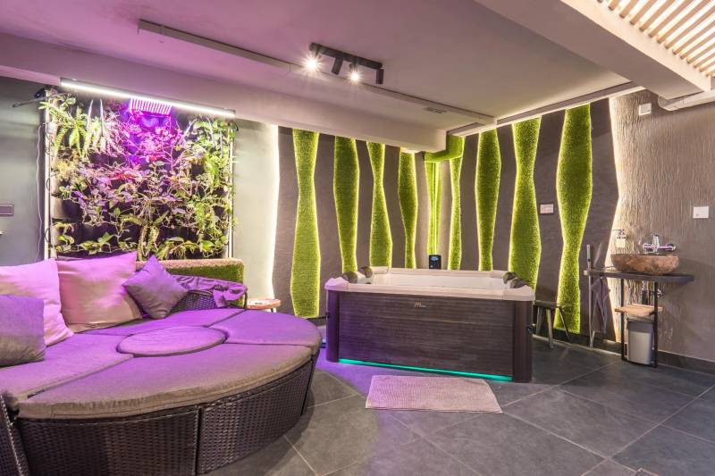 | Luxusný dvojúrovňový mezonet v Starom Meste - Relaxačná miestnosť s vírivkou, vertikálnou záhradou a pohodlným sedením v 3-izbovom byte.