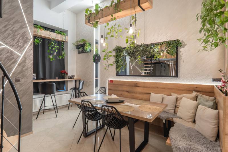 | Luxusný dvojúrovňový mezonet v Starom Meste - Jedáleň v 3-izbovom byte s bohatou zeleňou a vystlanými stoličkami, podlaha s dreveným dekorom.