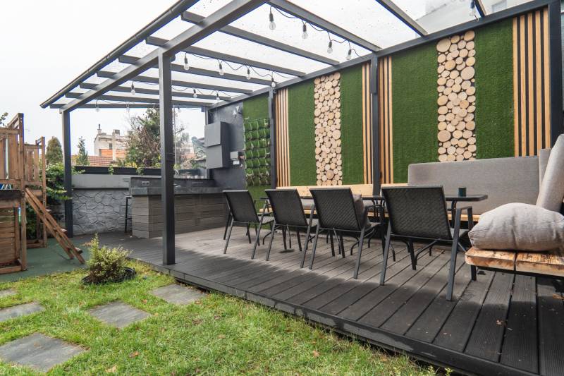 | Luxusný dvojúrovňový mezonet v Starom Meste - Záhradná terasa s prístreškom, drevenými dekoráciami a jedálenským stolom, ideálna na oddych.