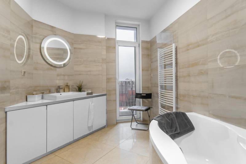 I Luxusný byt v historickom centre Bratislavy - Kúpeľňa v 2-izbovom byte s vaňou, umývadlom, zrkadlom a vyhrievaným rebríkovým radiátorom.