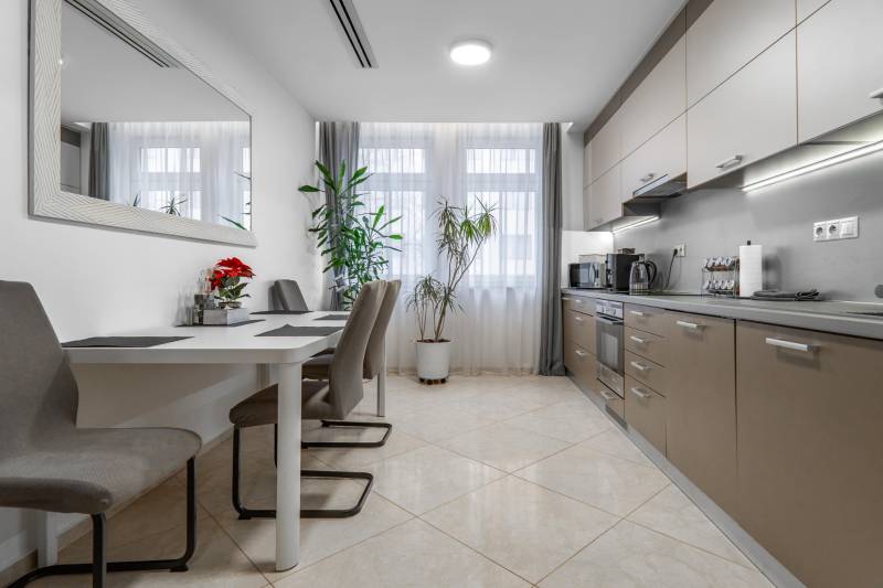 I Luxusný byt v historickom centre Bratislavy - Jedálenský kút s dlhým stolom, kuchynská linka, svetlé steny, 2-izbový byt.