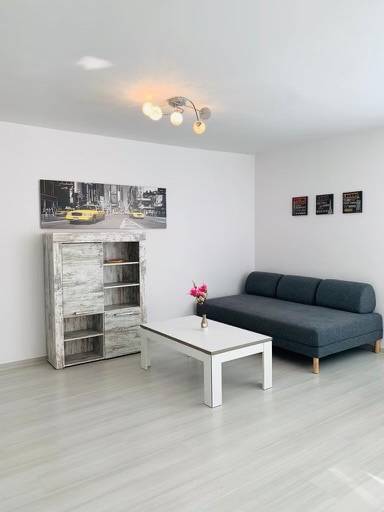 Na predaj 2-i byt s terasou pri Bratislavskom hrade - Obývačka na ulici Palisády. Svetlá 2-izbový byt so sedačkou a stolíkom.