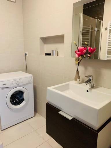 Na predaj 2-i byt s terasou pri Bratislavskom hrade - Kúpeľňa s práčkou, umývadlom a dekoráciou na ulici Palisády, 2-izbový byt.