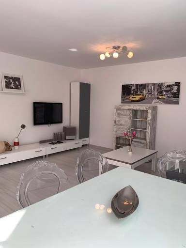 Na predaj 2-i byt s terasou pri Bratislavskom hrade - Obývačka v 2-izbovom byte na ulici Palisády s moderným nábytkom a obrazom.