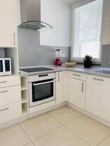 Na predaj 2-i byt s terasou pri Bratislavskom hrade - Biela kuchyňa s rúrou, drezom a mixérom v 2-izbovom byte na ulici Palisády.