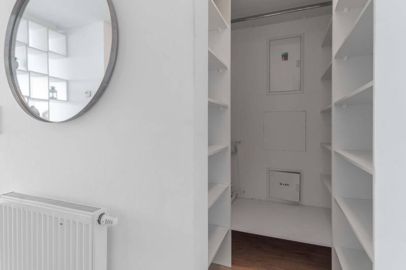 I na predaj 2i byt v komplexe Tri Veže na Bajkalskej - Biele police a zrkadlo v predsieni 2-izbového bytu s podlahou s dreveným dekorom.