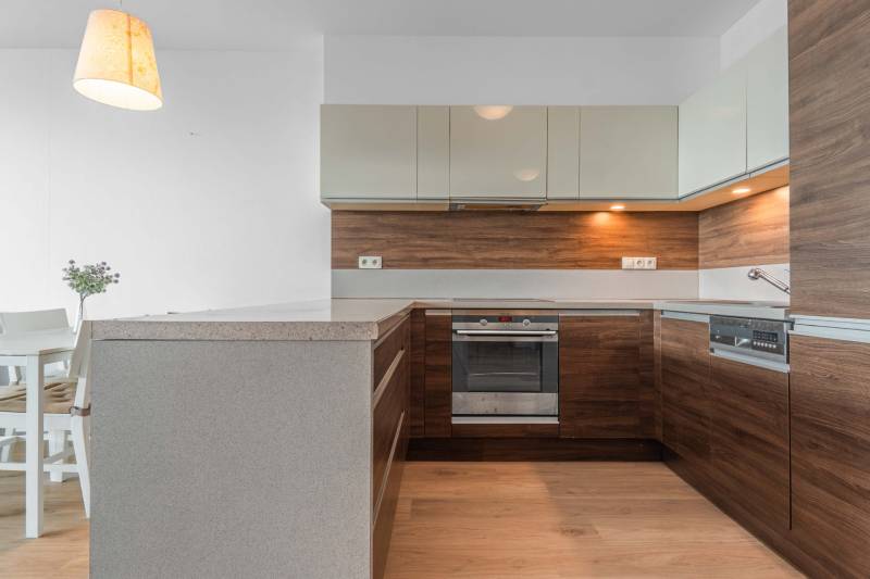 I na predaj 2i byt v komplexe Tri Veže na Bajkalskej - Kuchyňa v 2-izbovom byte s podlahou s dreveným dekorom a dreveným obkladom.