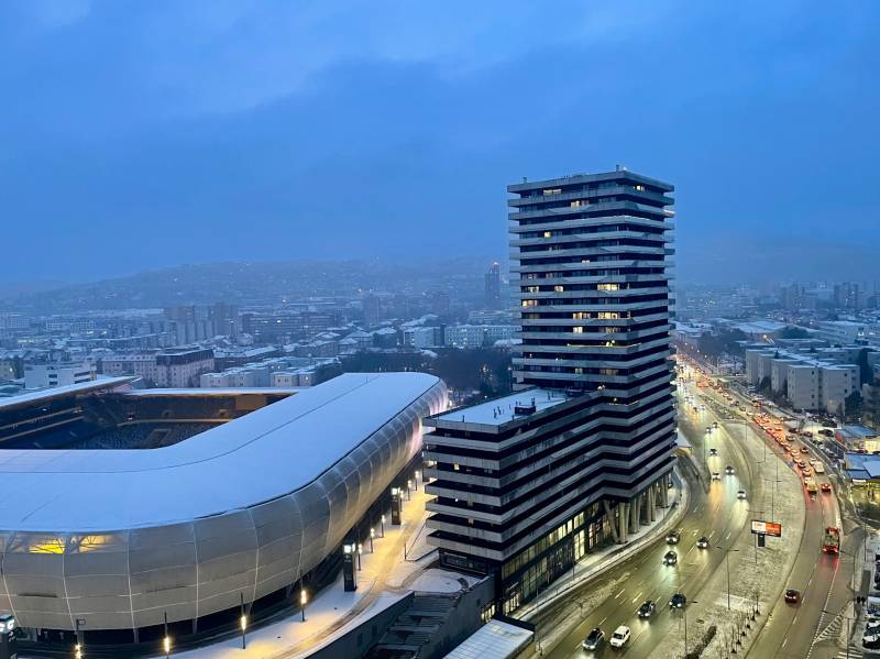 I na predaj 2i byt v komplexe Tri Veže na Bajkalskej - Zimná panoráma Bajkalskej ulice v Bratislave - Novom Meste s bytovým komplexom a štadiónom.