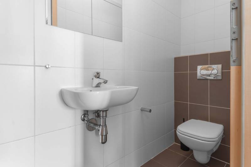 I na predaj 2i byt v komplexe Tri Veže na Bajkalskej - Toaleta so závesným WC a umývadlom v 2-izbovom byte s bielymi a hnedými kachličkami.