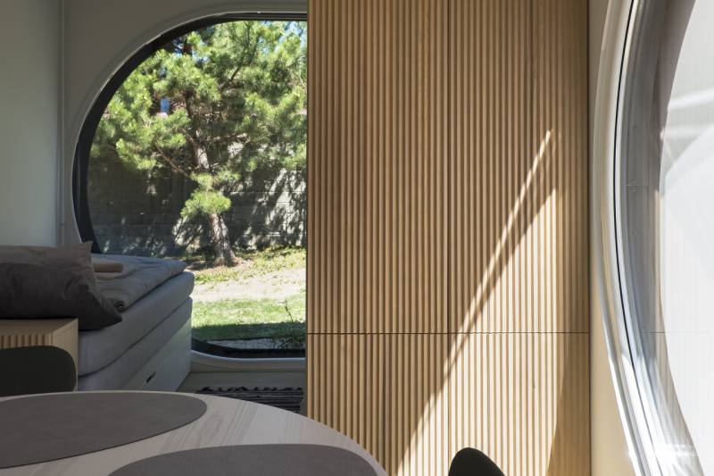 I Predaj Ecocapsule – autonómne ekologické bývanie - Interiér s kruhovým oknom, podlaha s dreveným dekorom, Zvláštne nehnuteľnosti.