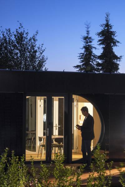 I Predaj Ecocapsule – autonómne ekologické bývanie - V Bratislave, zvláštne nehnuteľnosti s presklenými dverami, osvetlené v noci, obklopené zeleňou.