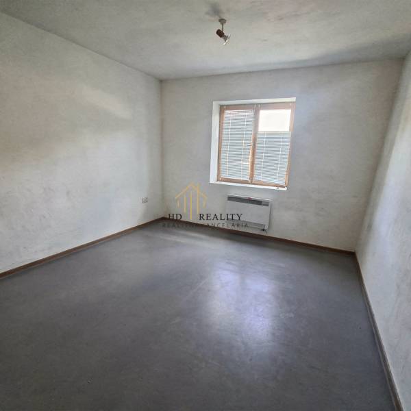 Predaj, výrobný a veľkoobchodný areál v okrese Veľký Krtíš - Izba s bielymi stenami, sivou podlahou a malým oknom vo výrobných priestoroch.