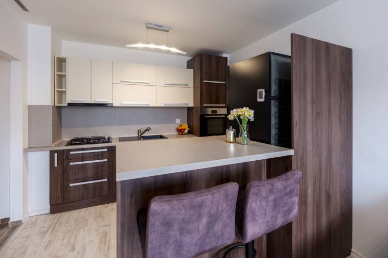 Prenájom Štýlový 2-iz bový byt pri OC Central BEZ PROVÍZIE!!!!  - Kuchyňa v 2-izbovom byte s barovým pultom, pult s podlahou s dreveným dekorom, stoličky.