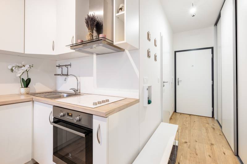 Prenájom 1-izbového bytu, Béžová, Béžová, Petržalka - REZERVOVANÉ - Svetlá kuchyňa s dreveným dekorom v 1-izbovom byte, vstupná chodba.