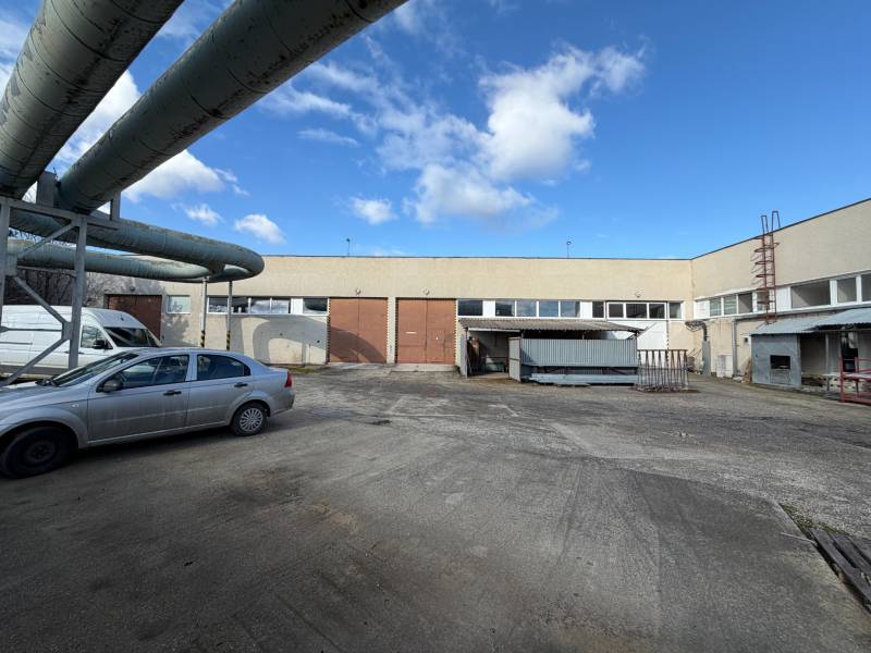 Predám skladovú halu v Nových Zámkoch - Sklady a haly v Nových Zámkoch na ulici Nové Zámky s priemyselným komplexom a autami.