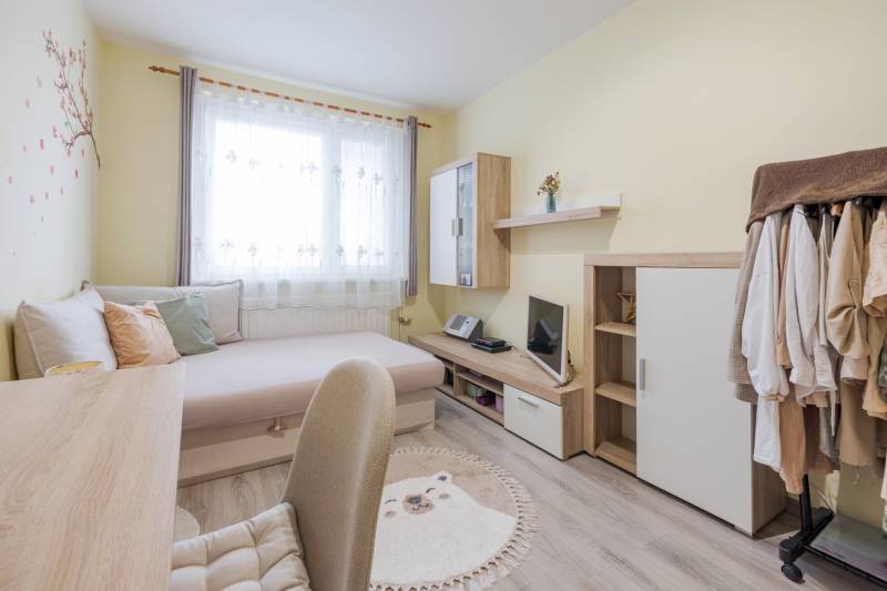 Predaj 4-izbového bytu, Vyšehradská, Vyšehradská, Petržalka - Svetlá izba s posteľou, pracovným stolom a skriňou v 4-izbovom byte.