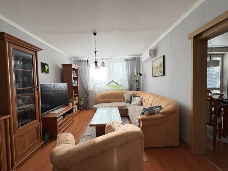 Vkusný 3 izb. byt po kompl. rekonštrukcii - Jilemnického ulica -72m2 - Obývacia izba s pohodlnou sedačkou, podlahou s dreveným dekorom a príjemným osvetlením v 3-izbovom byte.