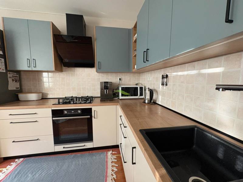 Vkusný 3 izb. byt po kompl. rekonštrukcii - Jilemnického ulica -72m2 - Kuchynská linka v 3-izbovom byte s podlahou s dreveným dekorom a spotrebičmi.