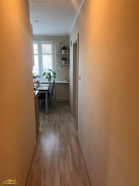 Na predaj  3-izbový byt v meste Rajec  - Úzka chodba v 3-izbovom byte vedie k svetlej jedálni s rastlinami a dekoráciami.