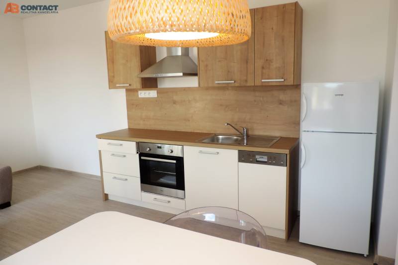 Moderná garsónka v obľúbenej Rezidencii Tematínska - Piešťany - Kuchyňa v garsónke na ulici Bodona s drevenými skrinkami, sporákom a chladničkou.