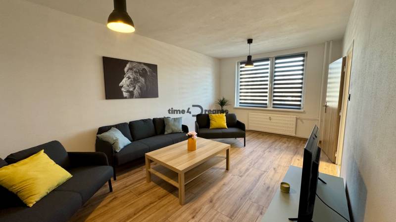 NA PRENÁJOM veľký 3 izbový byt na Čermáni NITRA - Obývacia izba s podlahou s dreveným dekorom, sedačka, konferenčný stolík, obraz leva.