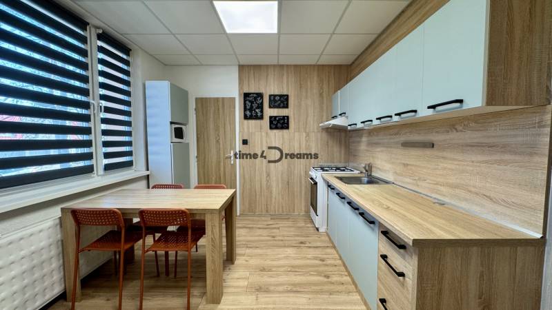 NA PRENÁJOM veľký 3 izbový byt na Čermáni NITRA - Kuchyňa v 3-izbovom byte s jedálenským stolom a podlahou s dreveným dekorom.