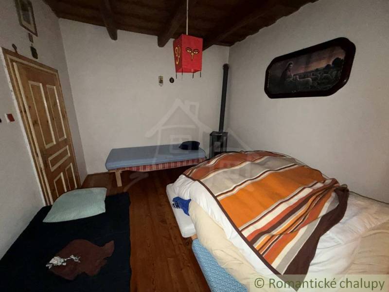 Exkluzívne: Pekná chalupa v obci Lipovec - Izba v rodinnom dome s dreveným dekorom podlahy a jednoduchým zariadením.