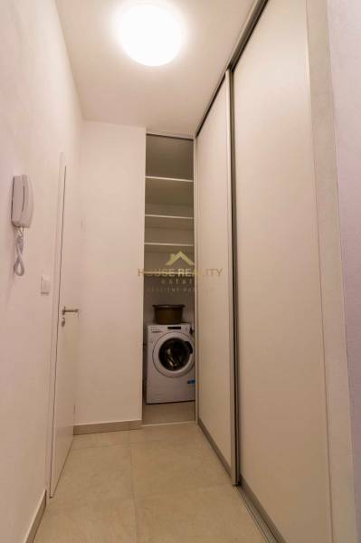 Novostavba 1 izbový byt, Bernolákovská ulica, Ivanka pri Dunaji - Úzka chodba v 1-izbovom byte s práčkou a posuvnými dverami.