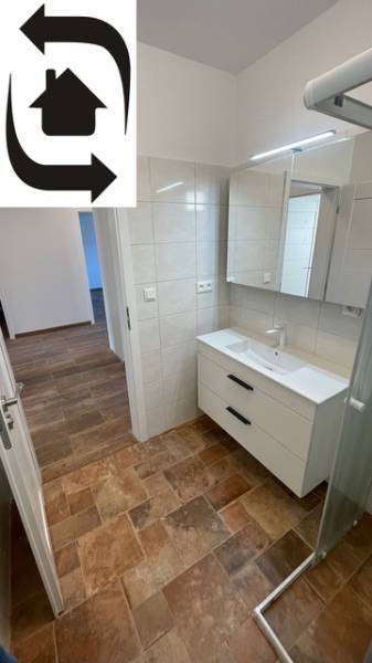 Rodinný dom na Devätinovej ulici na prenájom - Kúpeľňa v rodinnom dome s podlahou s dreveným dekorom a sprchovým kútom.