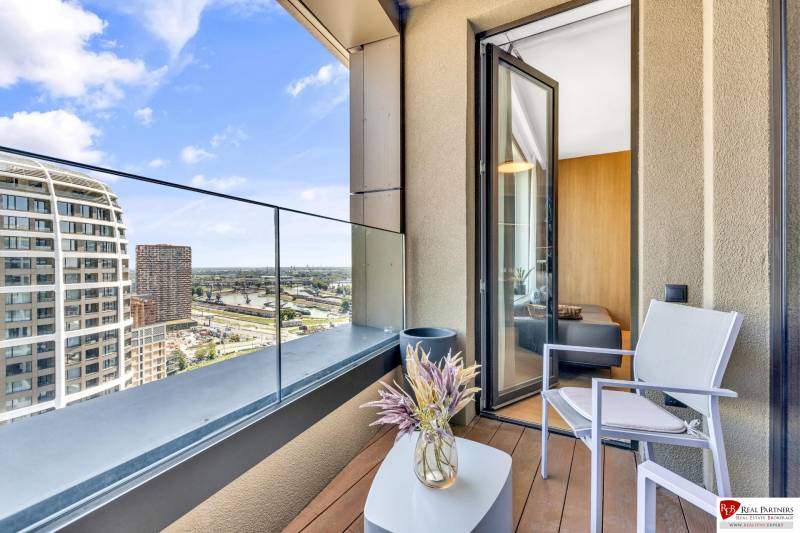 Predaj luxusný 2-izbový byt, 52 m2, Továrenská ul, SKY PARK - Balkón s výhľadom na mesto, konferenčný stolík, stolička a váza s rastlinou.