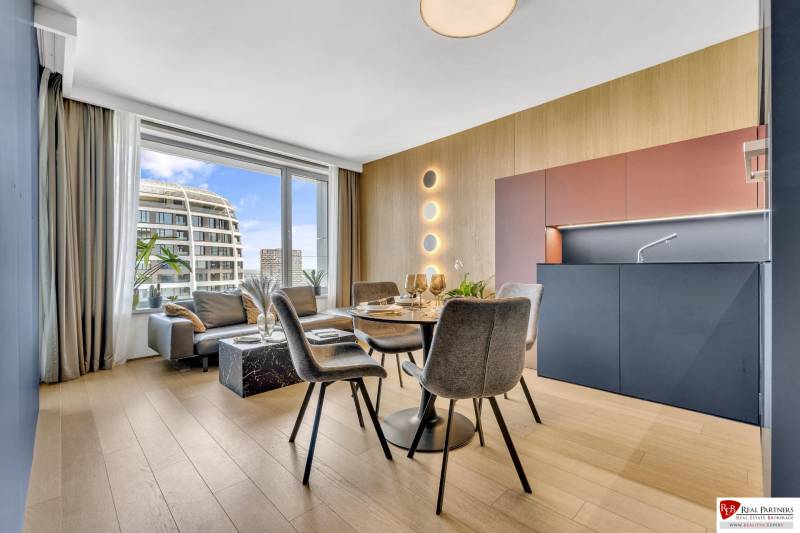 Predaj luxusný 2-izbový byt, 52 m2, Továrenská ul, SKY PARK - Jedálenský stôl s kreslami v 2-izbovom byte s podlahou s dreveným dekorom.