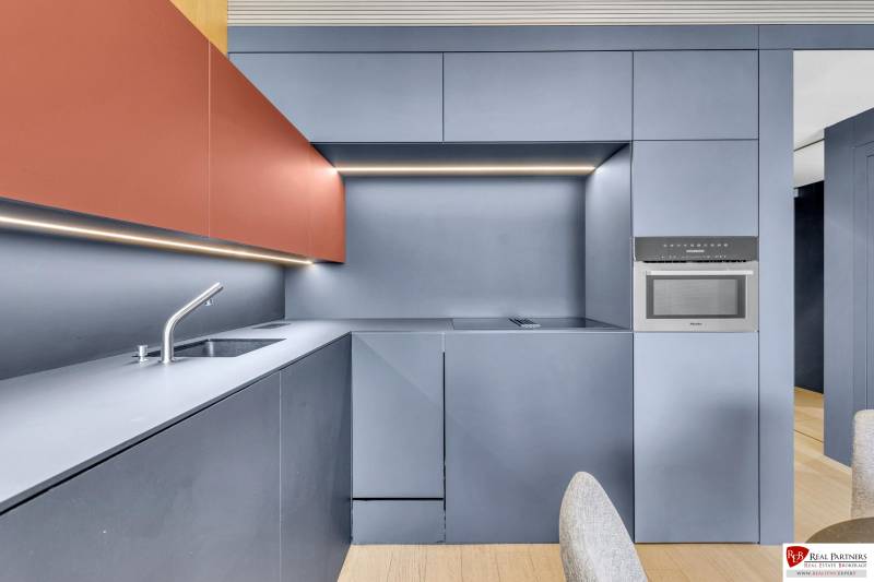 Predaj luxusný 2-izbový byt, 52 m2, Továrenská ul, SKY PARK - Štýlová kuchyňa v 2-izbovom byte s minimalistickými skrinkami a podlahou s dreveným dekorom.