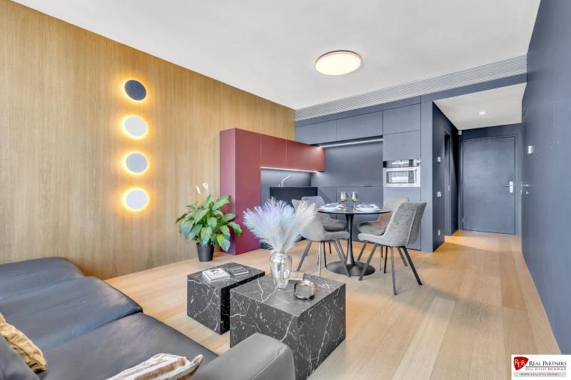 Predaj luxusný 2-izbový byt, 52 m2, Továrenská ul, SKY PARK - Obývačka v 2-izbovom byte s dekorom dreva a minimalistickým nábytkom.