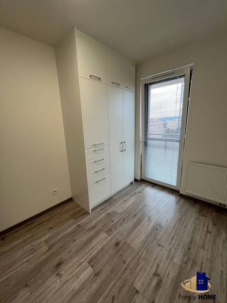 PRENÁJOM 3 izbový byt  Košice Residence Albelli - Staré Mesto - Izba s bielou skriňou, podlahou s dreveným dekorom a balkónovými dverami v 3-izbovom byte.