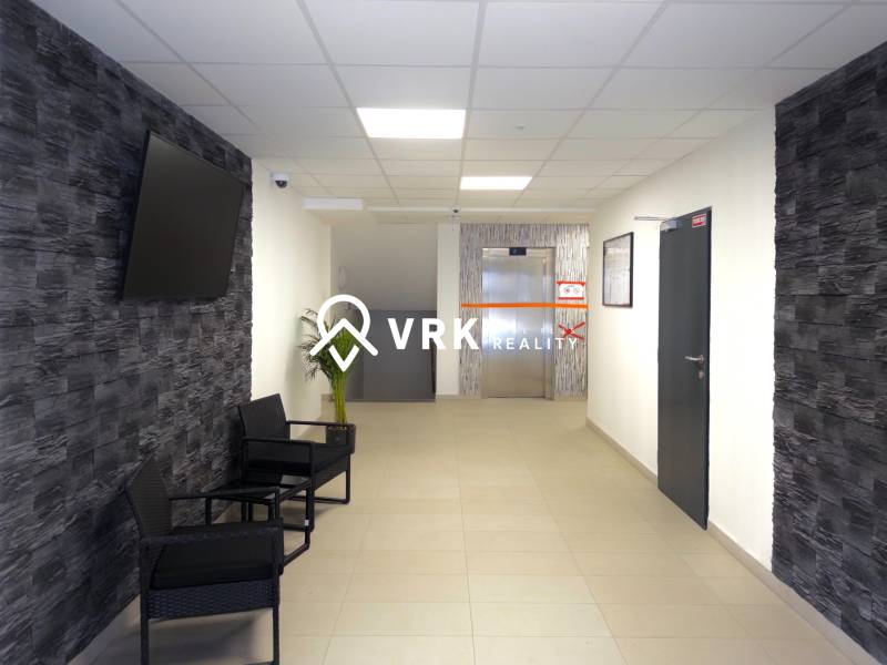 3-izbový byt s garážovým státím – Košice Západ, ul. Topoľčianska - Predsieň v 3-izbovom byte s TV na stene a výťahom v pozadí.