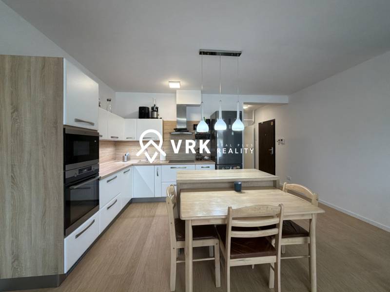 3-izbový byt s garážovým státím – Košice Západ, ul. Topoľčianska - Kuchyňa v 3-izbovom byte s podlahou s dreveným dekorom a jedálenským stolom.