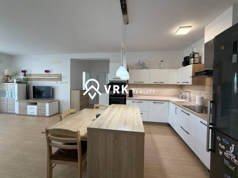 3-izbový byt s garážovým státím – Košice Západ, ul. Topoľčianska - Kuchyňa v 3-izbovom byte, podlaha s dreveným dekorom, moderné spotrebiče a jedálenský stôl.