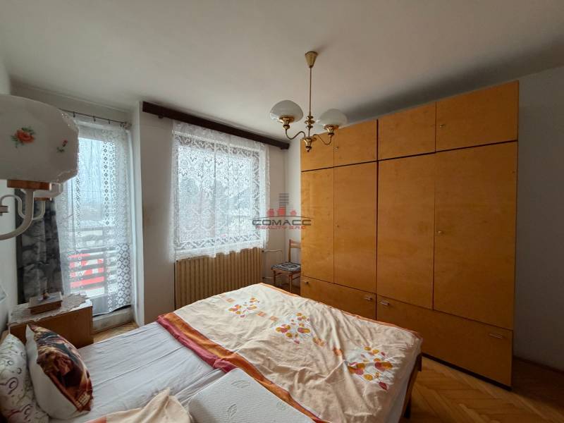 Exk. viacgeneračný RD vo Veľkom Orvišti pri Piešťanoch REZERVOVANÝ - Spálňa s manželskou posteľou, nábytkom a podlahou s dreveným dekorom v rodinnom dome.