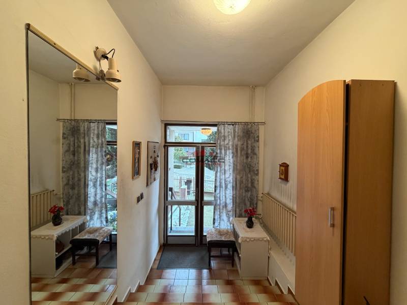 Exk. viacgeneračný RD vo Veľkom Orvišti pri Piešťanoch REZERVOVANÝ - Interiér rodinného domu so zrkadlom, skriňou, dlažbou a pohľadom na záhradu.