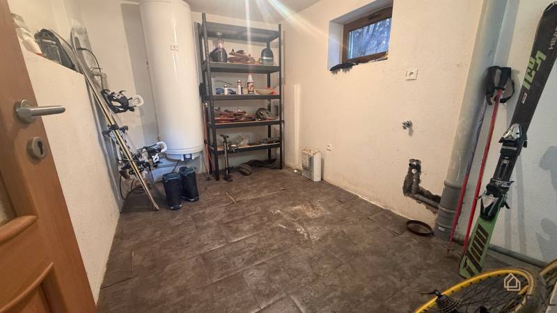 Moderný 5-izbový rodinný dom po kolaudácii 2025 | 2-generačné bývanie  - Skladový priestor v rodinnom dome s regálom a športovým vybavením, podlaha s dreveným dekorom.