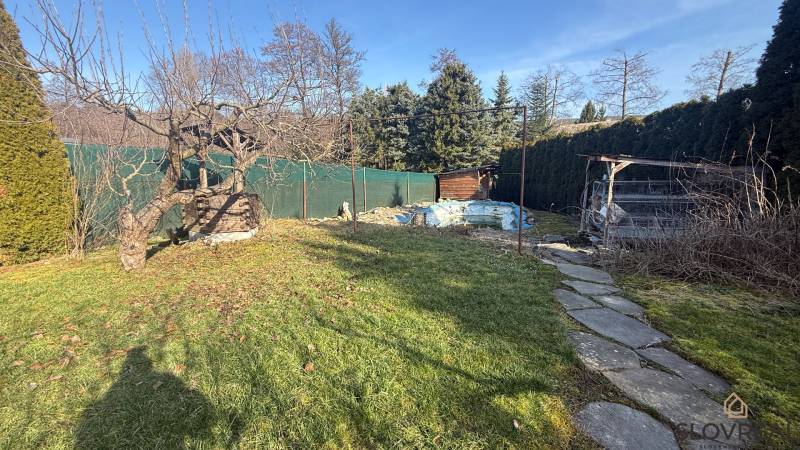 Moderný 5-izbový rodinný dom po kolaudácii 2025 | 2-generačné bývanie  - Záhrada rodinného domu v Lutile s drevinami a chodníkom v slnečnom prostredí.