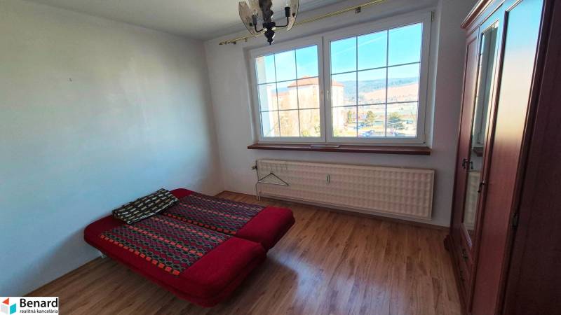 NA PRENÁJOM 1,5 IZBOVÝ, UL. MIEROVÁ - Spálňa s posteľou, skriňou a podlahou s dreveným dekorom v 2-izbovom byte.