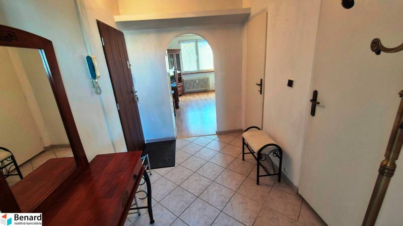 NA PRENÁJOM 1,5 IZBOVÝ, UL. MIEROVÁ - Chodba s oblúkovým prechodom v 2-izbovom byte, podlaha s dreveným dekorom, zrkadlo, lavička.