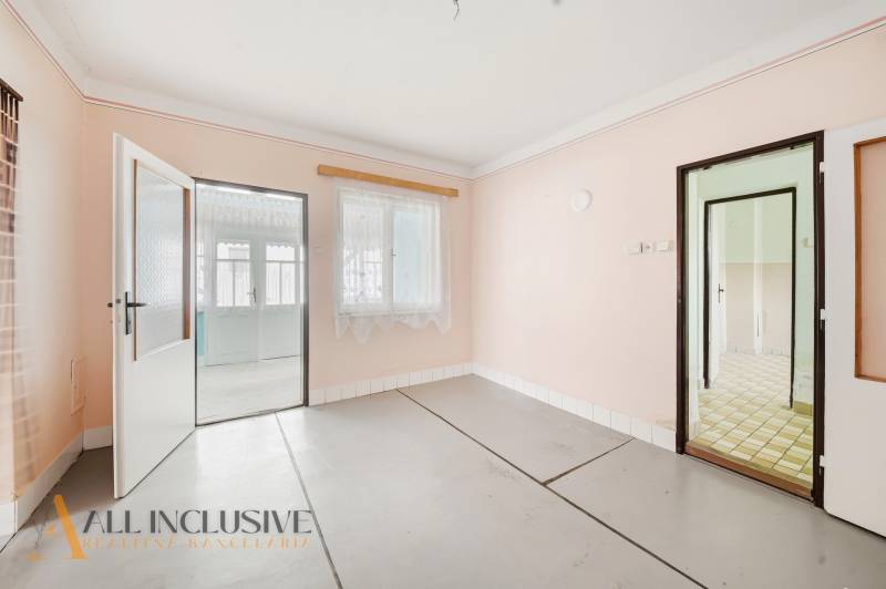 Na predaj 4-izbový rodinný dom, Topoľníky - Interiér rodinného domu s bielymi stenami a presklenými dverami bez dreveného dekoru.