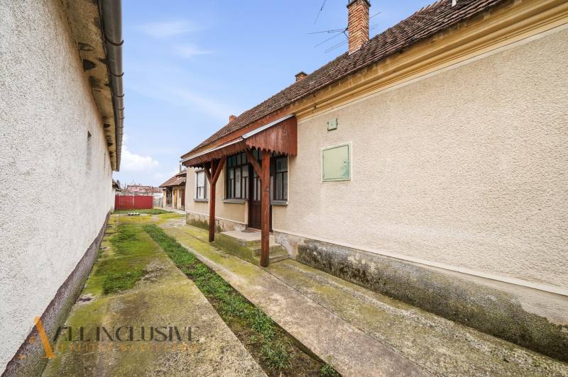 Na predaj 4-izbový rodinný dom, Topoľníky - Rodinný dom v Topoľníkoch s udržiavanou fasádou, verandom a betónovým chodníkom.