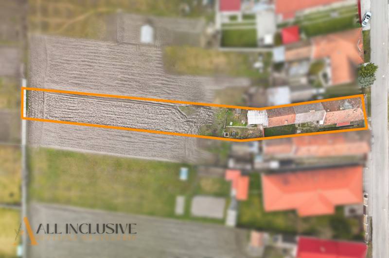 Na predaj 4-izbový rodinný dom, Topoľníky - Rodinný dom v Topoľníkoch so záhradou v orámovaní, viditeľné poľnohospodárske pole a budovy.