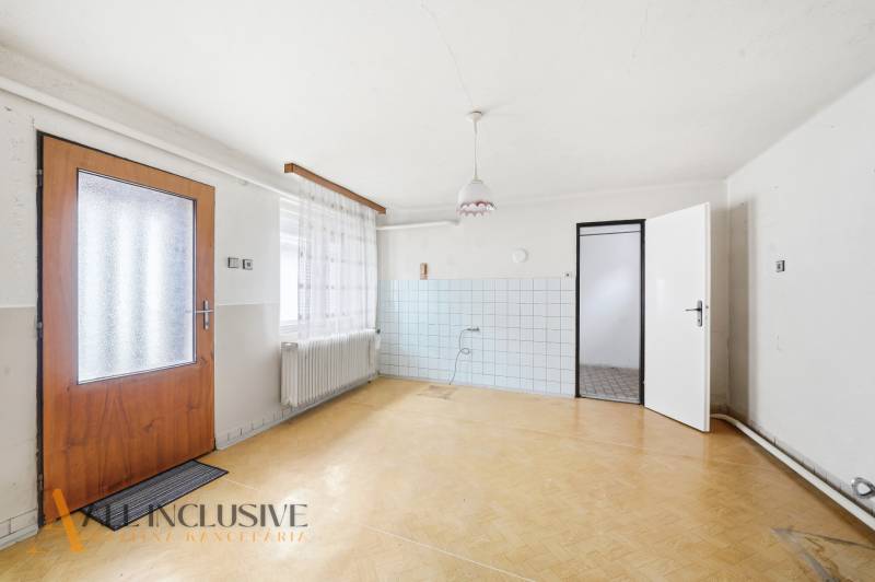 Na predaj 4-izbový rodinný dom, Topoľníky - Interiér rodinného domu s podlahou s dreveným dekorom a bielymi stenami.