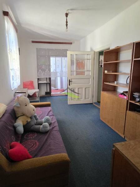 Rodinný dom v obci Pavlovce nad Uhom - Obývacia izba rodinného domu s pohovkou, policovou skriňou a hračkou na podlahe.