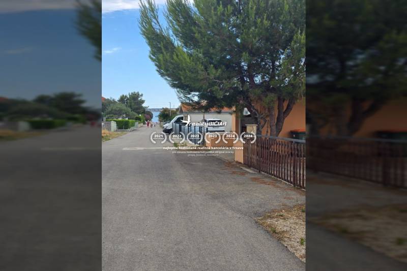 VRSI - dom s dvoma bytovými jednotkami - 250 m od mora - Ulica Mulo vo Vrsi so stromami a zaparkovanými autami, Zvláštne nehnuteľnosti.