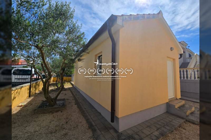 VRSI - dom s dvoma bytovými jednotkami - 250 m od mora - Žltý dom so schodmi a stromami v záhrade na ulici Mulo v meste Vrsi.